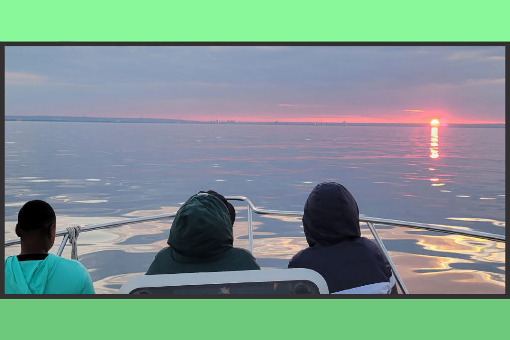 Three close friends on a boat at sunset 